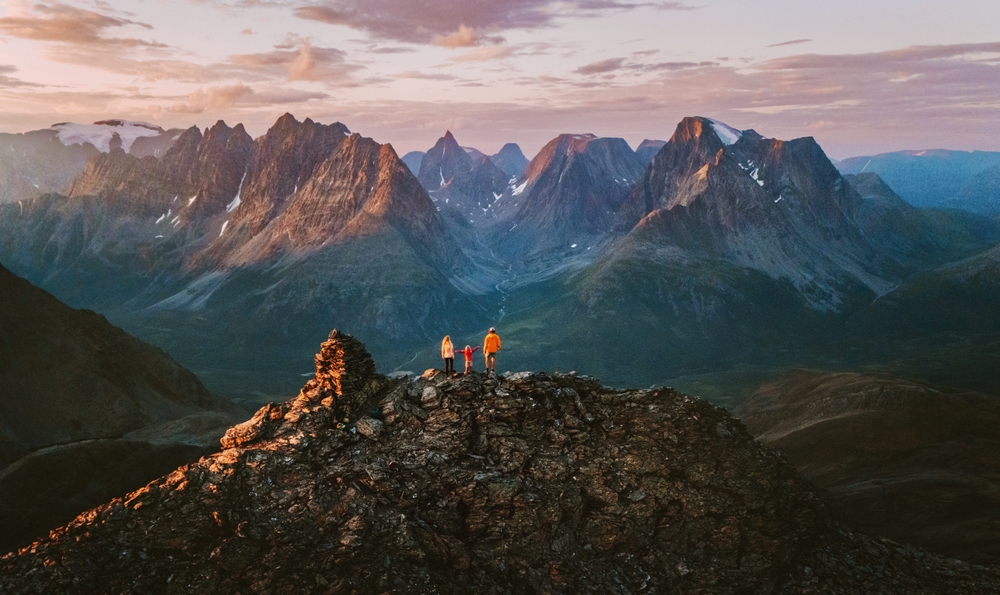 aerial view of mountains with a family standing between traveling to norway