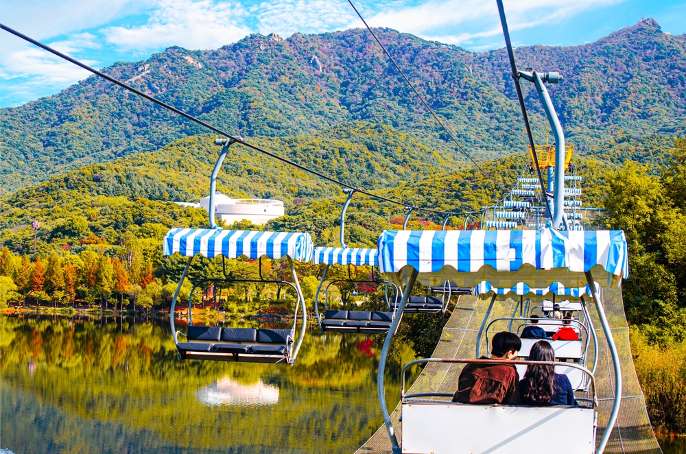 couple sitting on a cable car going towards the mountains