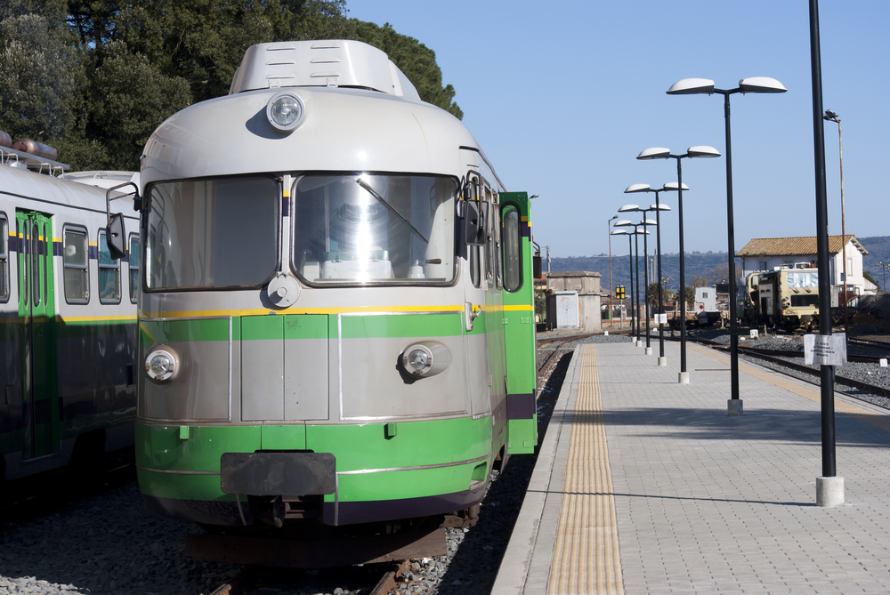 green colored train on a platform