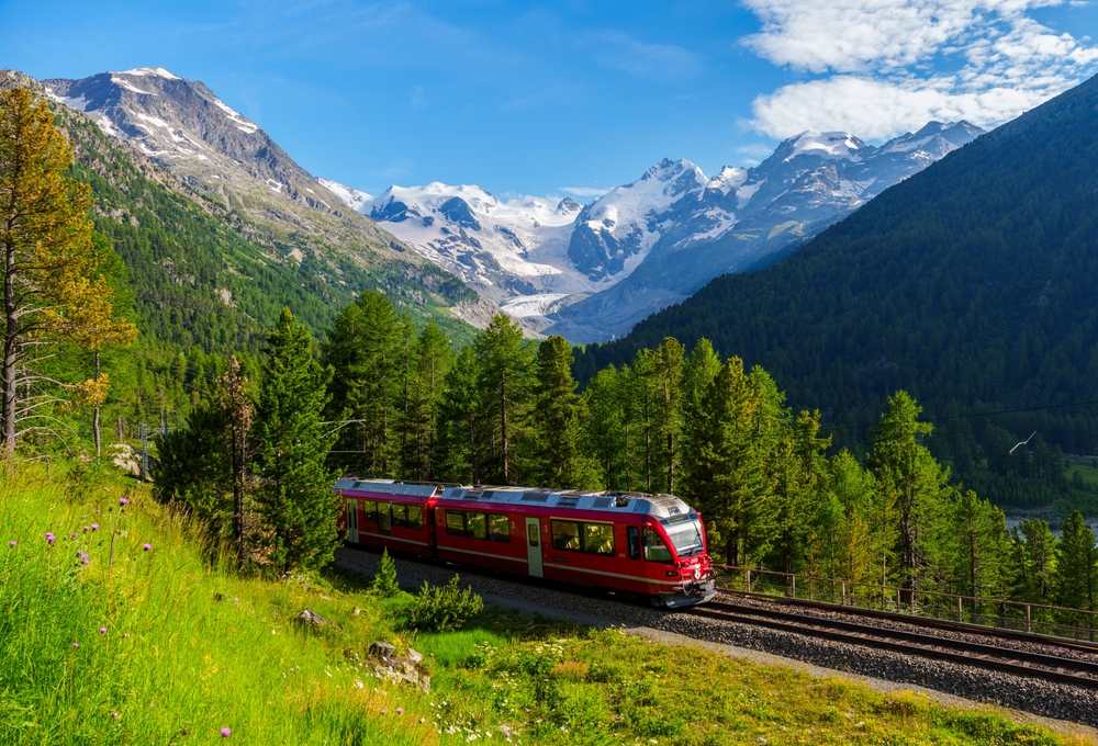 red colored train in front of mountains