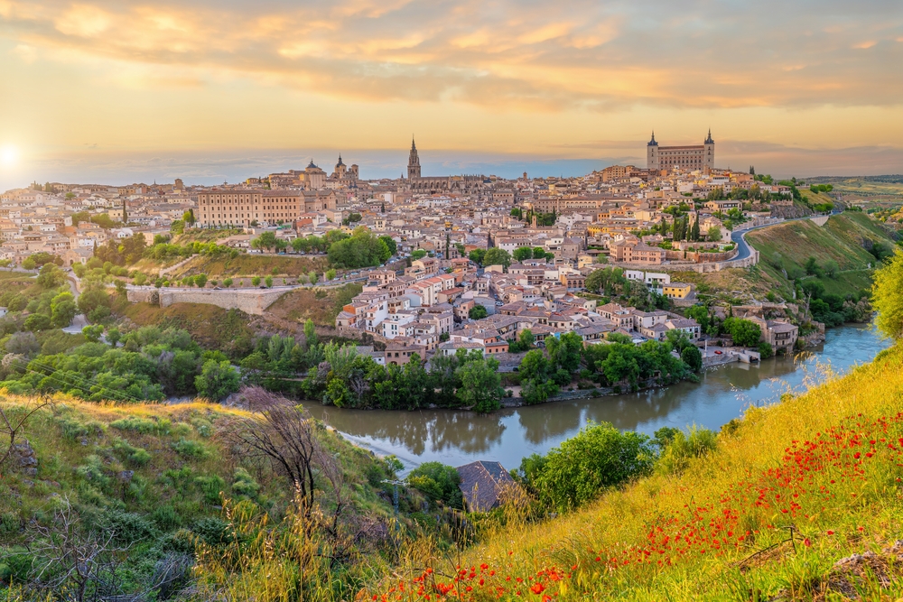 distance view of a city surrounded by river and greenery