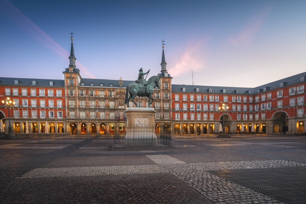 old town square with statue in evening