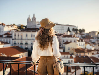 woman wearing shorts and shirt and cap looking at the city things to do in madrid
