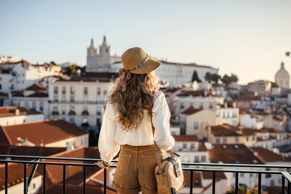 woman wearing shorts and shirt and cap looking at the city things to do in madrid