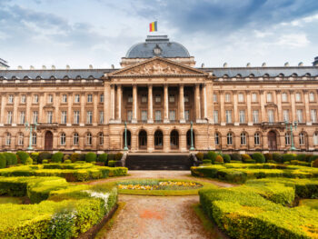 old building with belgium flag and garden in front of it brussels itinerary