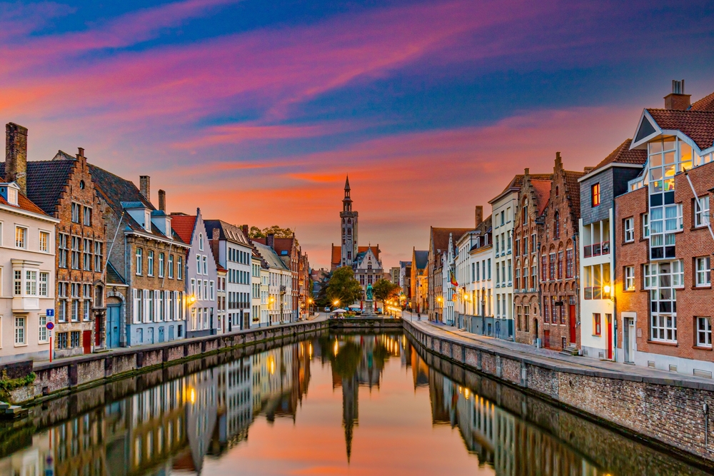 canal view with buildings on both sides during orange sky cities in belgium