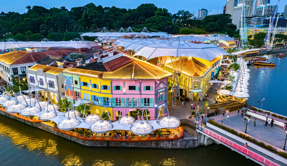 colorful houses on waterfront with greenery in background.