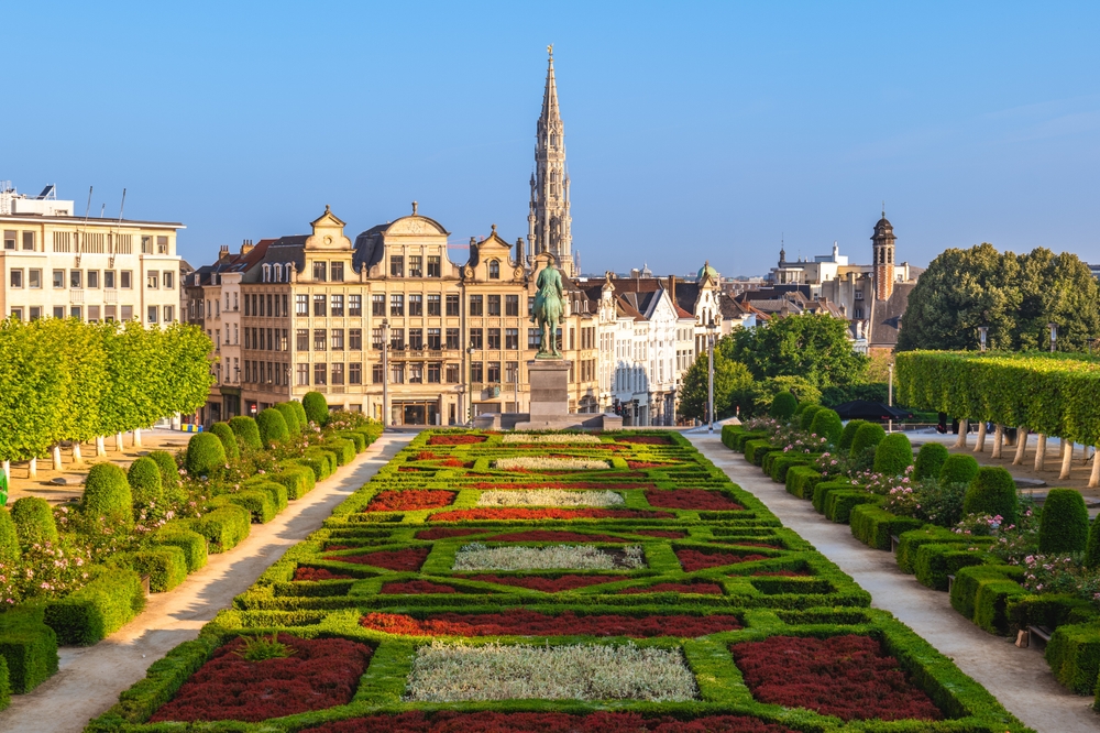 Gothic building in background with ornate gardens in foreground. Traveling to Belgium article