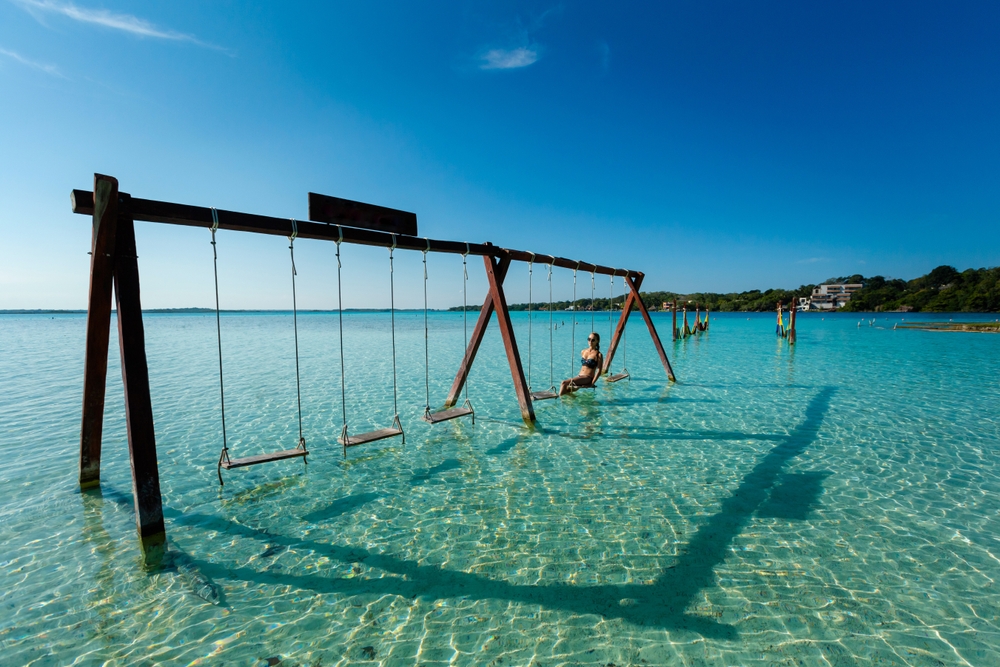 girl on a swing on a beach cancun travel tips