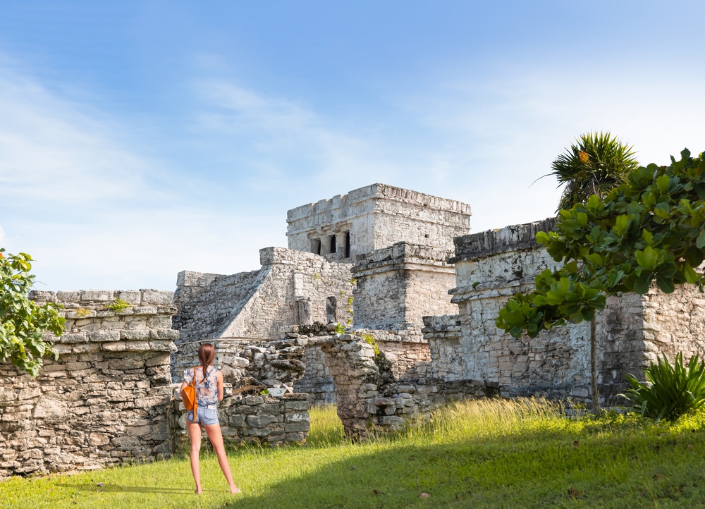 girl standing in front of mayan ruins cozumel travel tips
