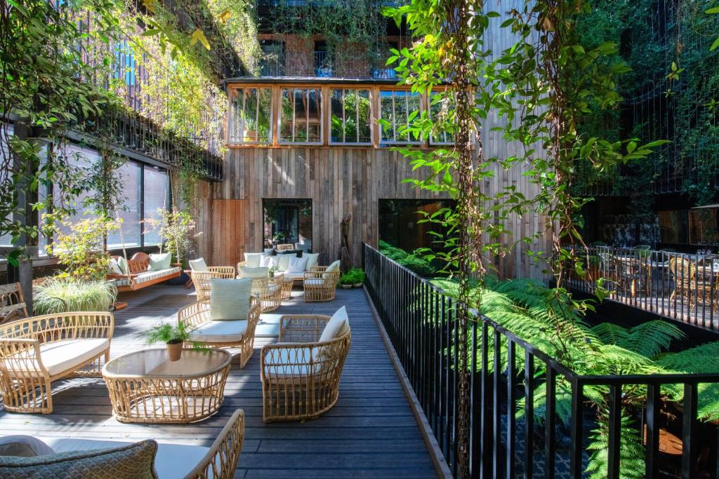 Outdoor plant oasis in a hotel with chairs and tables outside. 
