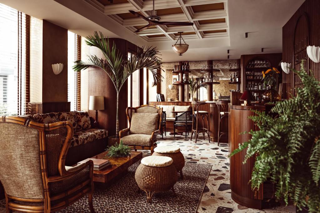 Hotel bar with lots of greenary and wooden furniture. This article is about the best boutique hotels in Paris.