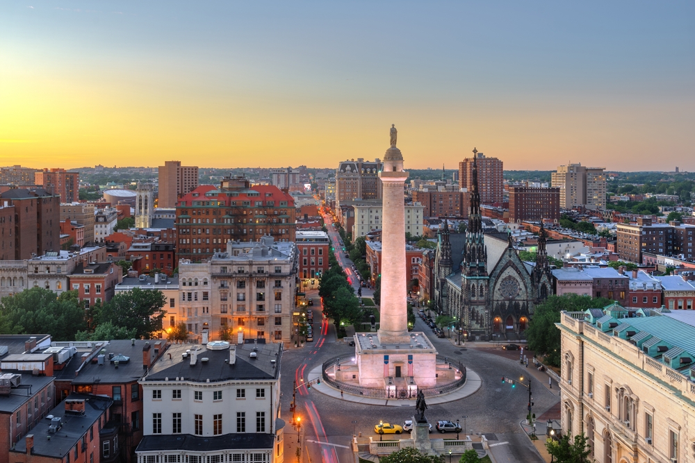 aerial view of a tall statute with buildings around it traveling to baltimore