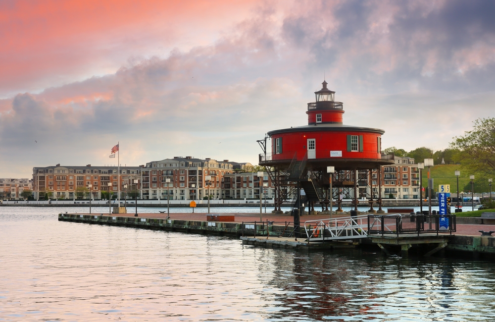 red color round lighthouse with buildings in the background