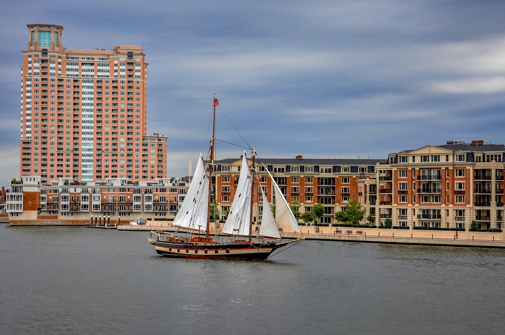 ship sailing on the water with buildings in the backdrop baltimore inner harbour