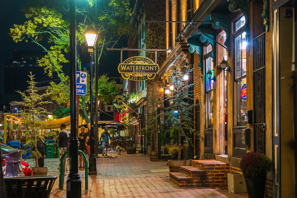 Historic brick buildings along Thames street in downtown Fell's Point neighborhood restaurants and bars for dining. You can see a street lit up at night