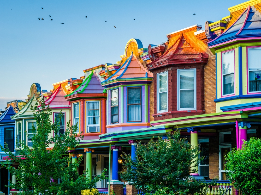 Colorful row houses on Guilford Avenue, in Charles Village, Baltimore, Maryland. The houses are bright colors and all different. The article is about a Baltimore weekend getaway.